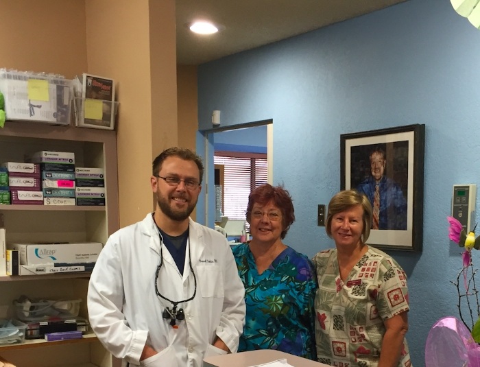 Doctor Rodda smiling with two Phoenix dental team members