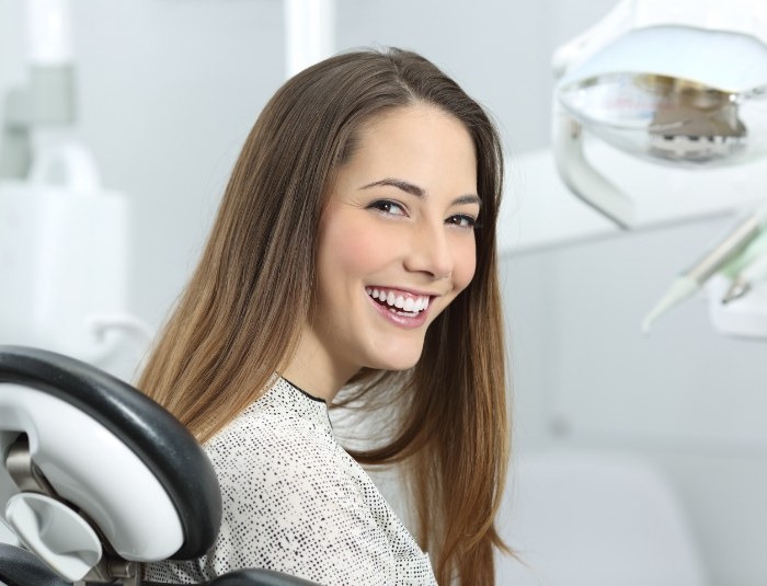 Brunette woman smiling in dental chair
