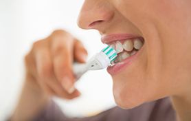 a person brushing and caring for their dental implants