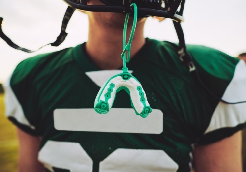 Athletic mouthguard hanging from football helmet