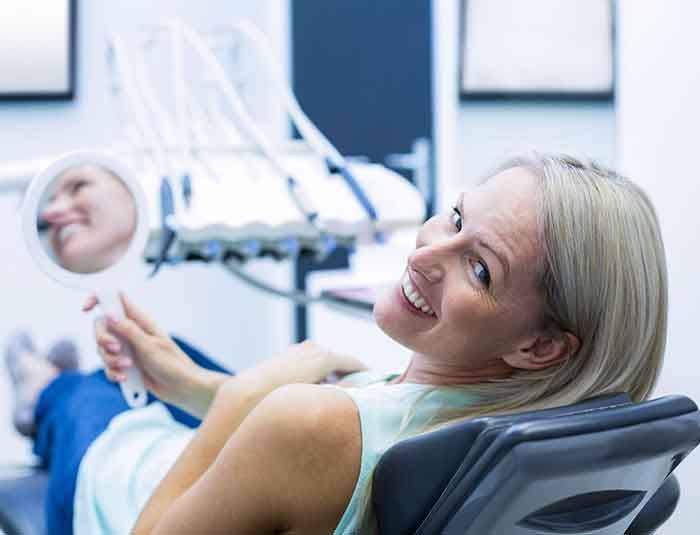 Doctor Rodda with dental patient holding plastic bag with old dental work