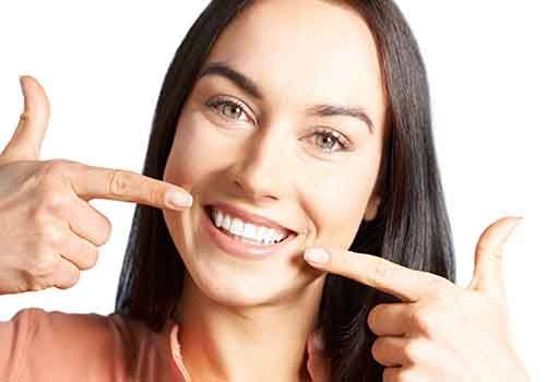 Smiling woman pointing to her teeth