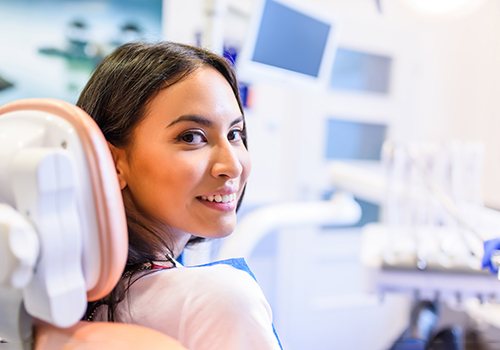 A smiling and relaxed young woman sitting in a dental chair