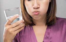 Woman swishing warm salt water around her mouth