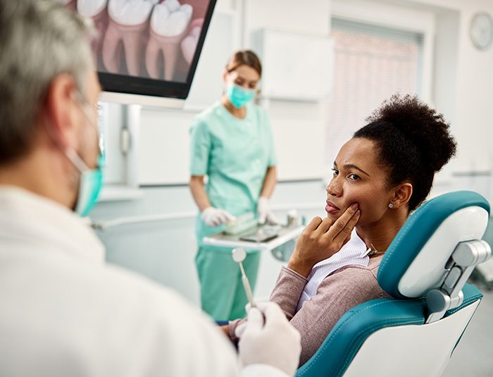 Woman with toothache talking to dentist