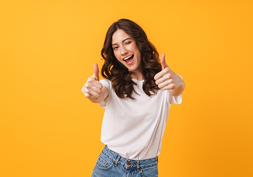 Woman winking giving two thumbs up